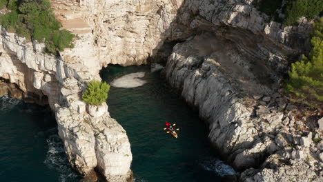 Acantilados-Y-Cuevas-Aislados-Cerca-De-Pula-Istria,-Croacia-Con-Turistas-En-Kayak-Dentro-De-La-Zona