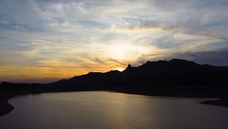 Aerial-shot-of-a-golden-hour-reflection-on-the-surface-of-a-natural-lake