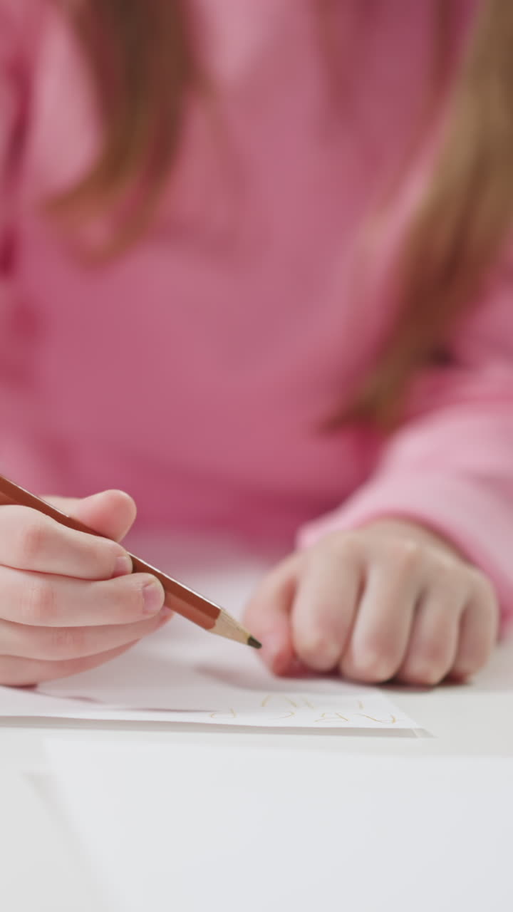 Little girl student writes letters with pencil on paper sheet learning English language with African-American teacher at home lesson closeup slow motion