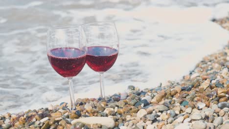 two glasses of red wine on the beach