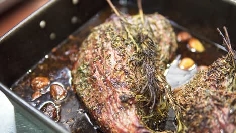 close-up of a stew with rosemary and garlic in a tray fresh from the oven