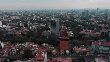 Drone-footage-of-Mexico-City-showcasing-highways,-streets,-cars,-homes,-and-distant-mountains-against-the-skyline