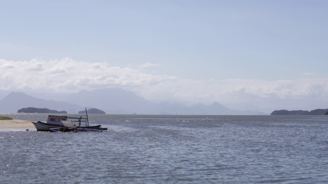 Steady shot of Carioca Bay near Paraty with old boats and mountains, Brazil