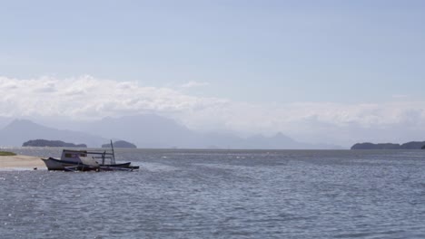 steady shot of carioca bay near paraty with old boats and mountains, brazil