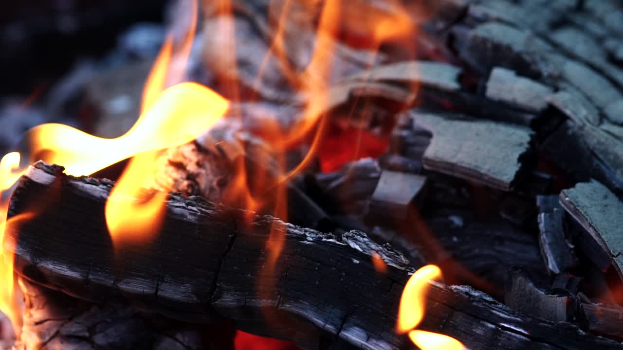Wood and embers burning in orange flames. Bonfire. Slow motion