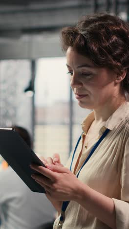 vertical video woman business consultant examines charts and icons on tablet