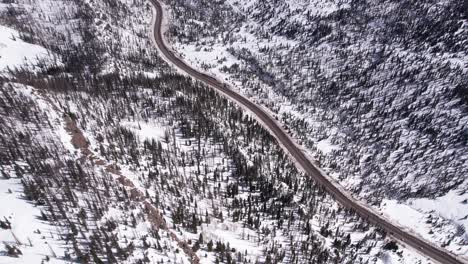 aerial view of road in valley and snowy winter landscape of colorado usa, drone shot
