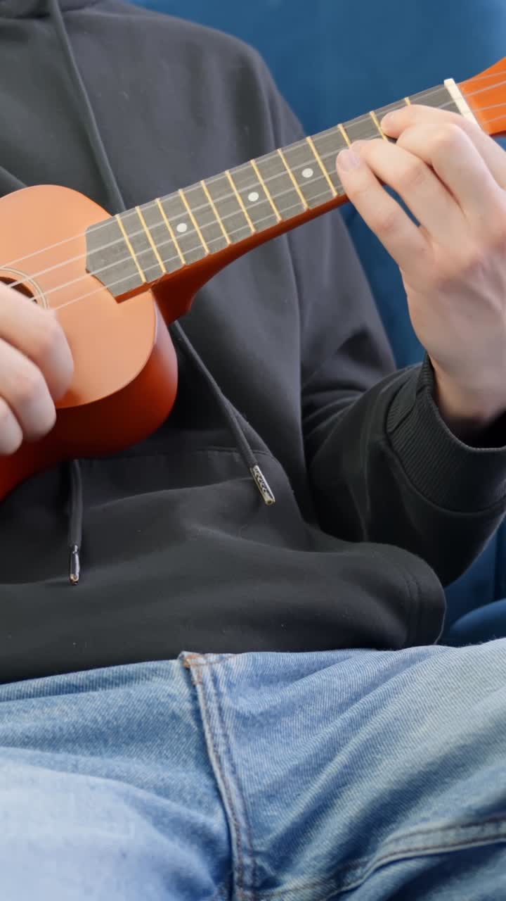 Vertical view of man playing ukulele