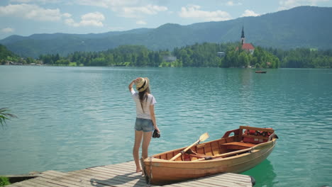 woman taking pictures of a scenic lake and island