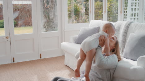 madre feliz jugando con el bebé en casa juguetón divirtiéndose con el niño sonriendo madre disfrutando de la maternidad 4k
