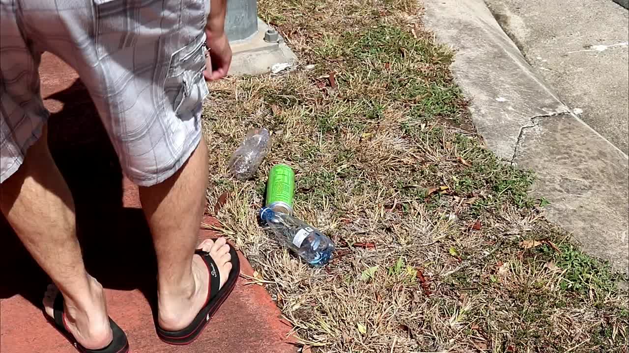 Man picking up plastic bottles and cans for recycling