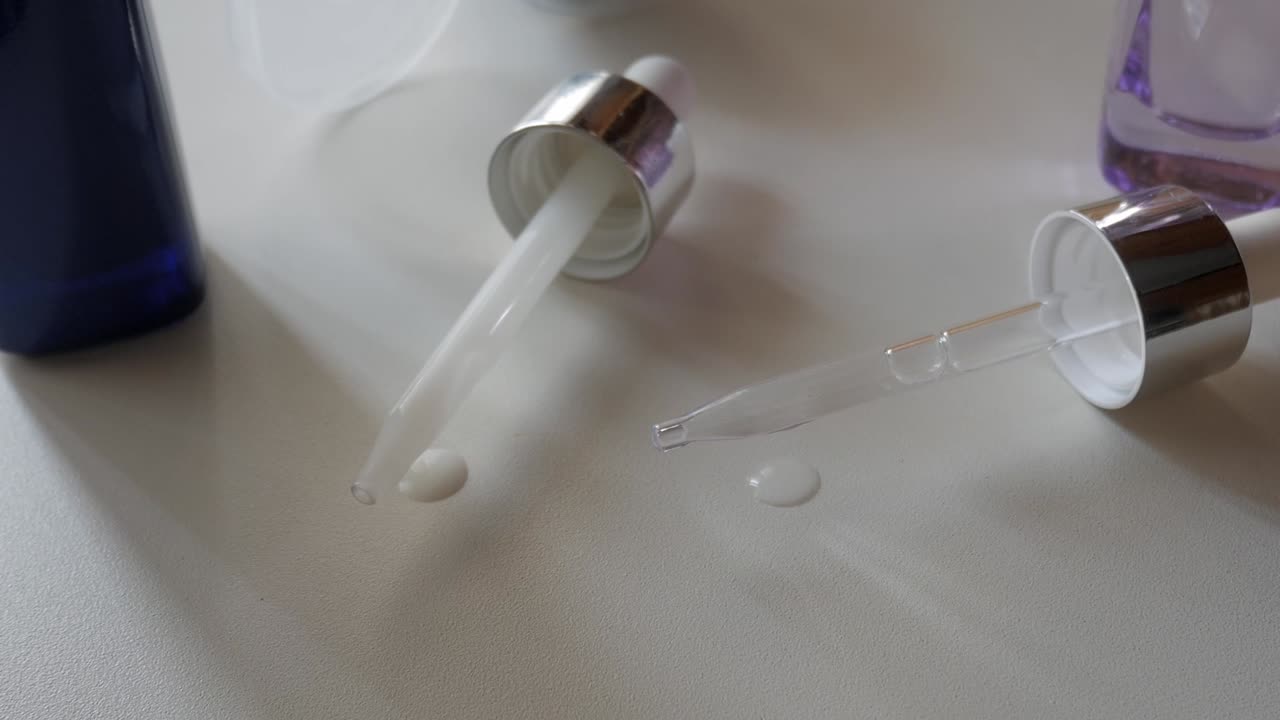 Two serums dropped from pipettes, hyaluronic acid and retinol texture comparison