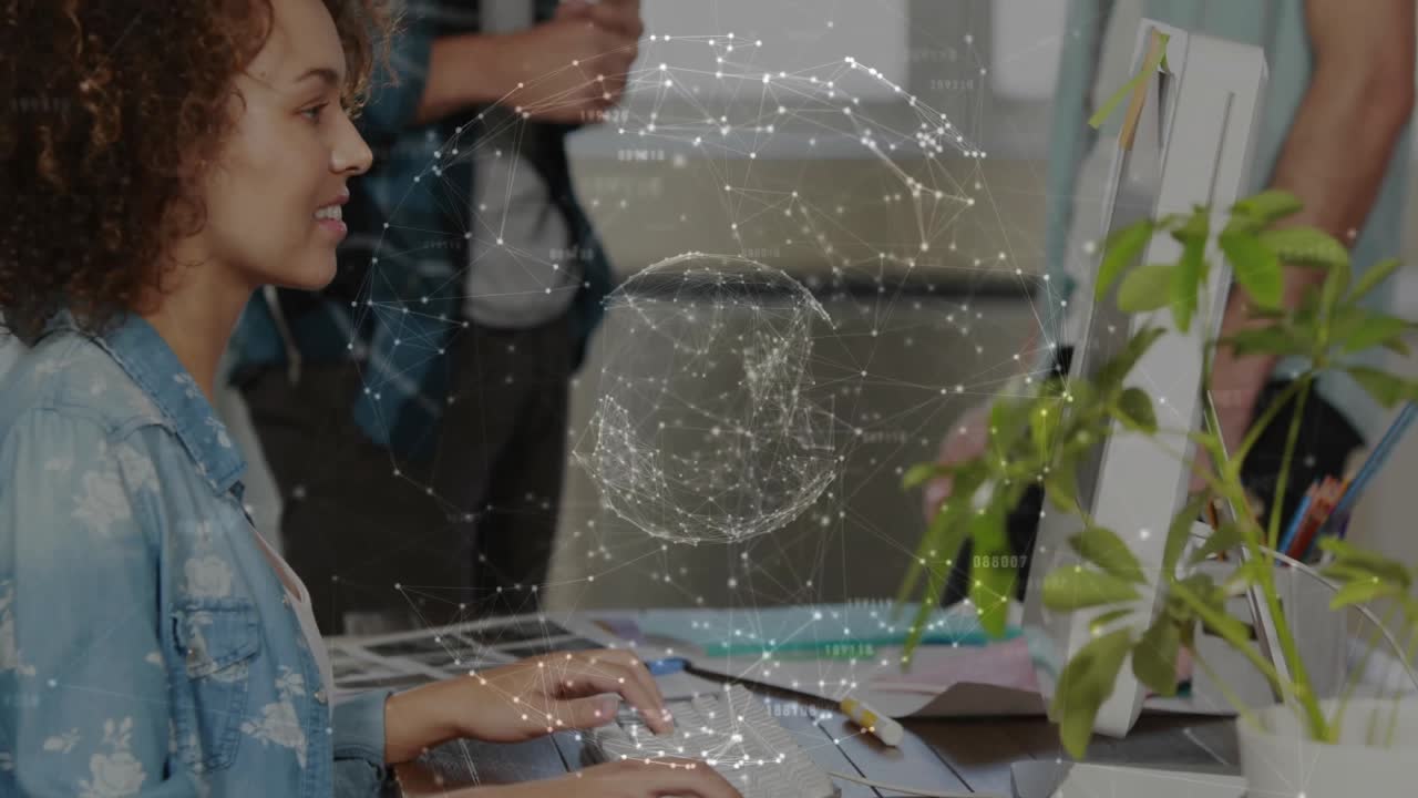 Woman typing at workstation with translucent globe overlay boosting technology teamwork gestures