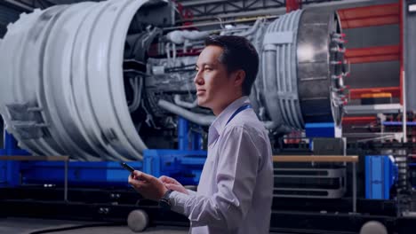 engineer inspecting jet engine in manufacturing facility