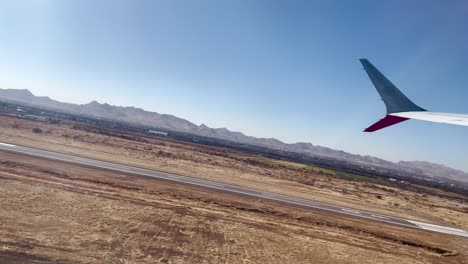 shot of airplane window seat during take off in chihuahua desert