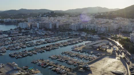 harbour on the island of ibiza in summer time with a lot of boats and mountains in the back