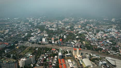 aerial scenic drone footage of the city of chiang mai, thailand covered in smog on a sunny day during the smokey burning season