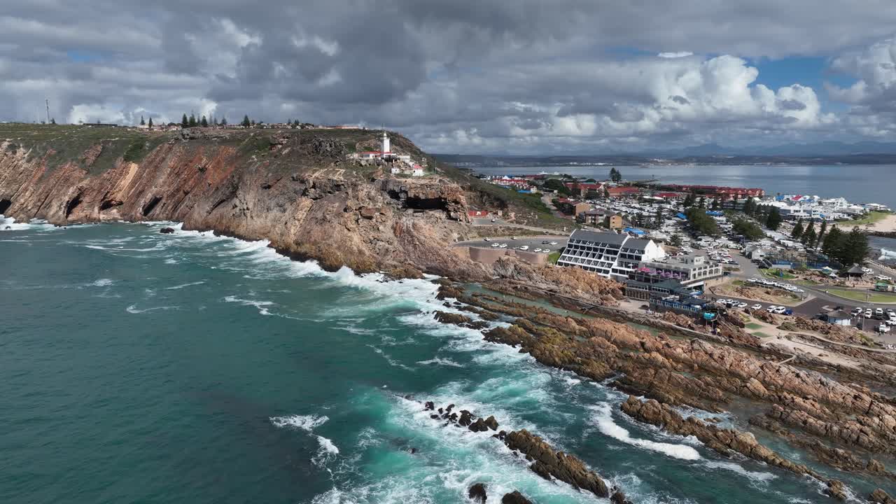 Vista aerea: onde dell'oceano si infrangono sulle rocce sotto il faro di Cape St Blaize