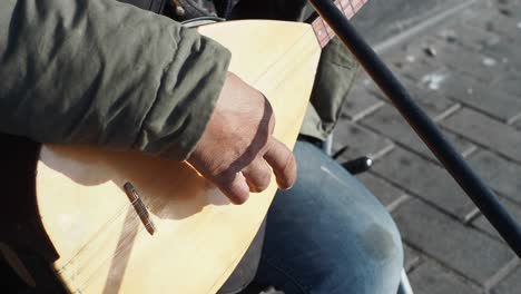 un hombre tocando un saz, un instrumento de cuerda tradicional turco