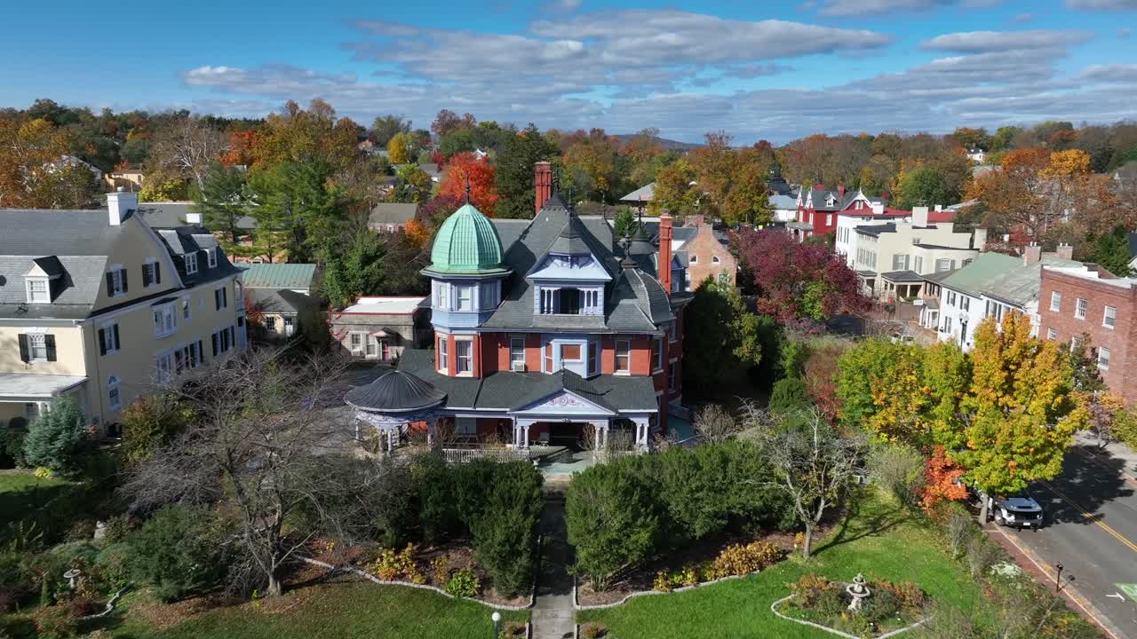 casa victoriana con una cúpula verde y árboles de otoño