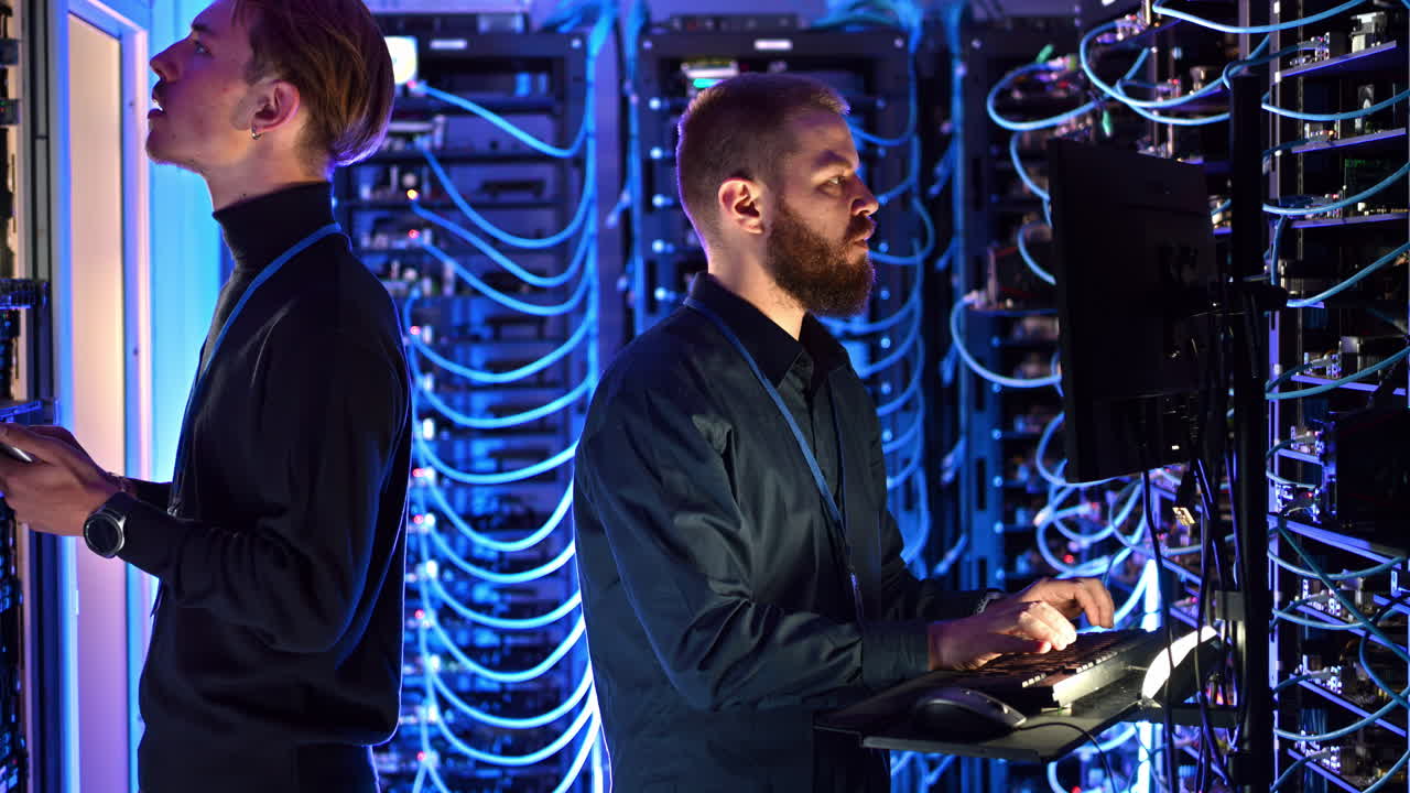 Two men managing data in a server room