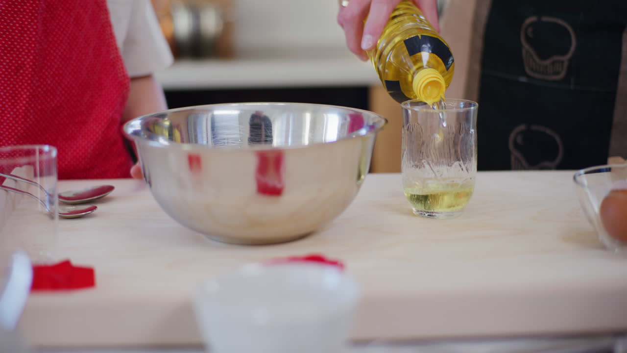 hombre vierte aceite vegetal en el vidrio mientras hornea pastel