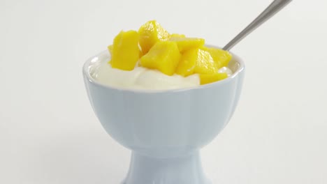 chopped mangoes with cream in bowl