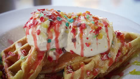 waffles belgas de confeti rellenos de cereal de arroz con guijarros afrutados y cubiertos con helado y jarabe, cerca de 4k