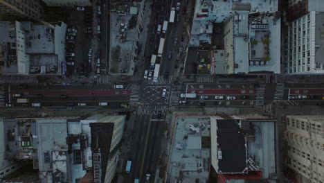 Vista-Aérea-De-Pájaros-Vista-De-Arriba-Hacia-Abajo-Del-Tráfico-En-Las-Calles-De-La-Ciudad.-Los-Coches-Se-Ponen-Verdes-En-Los-Semáforos-En-La-Intersección-De-Carreteras.-Manhattan,-Ciudad-De-Nueva-York,-Estados-Unidos