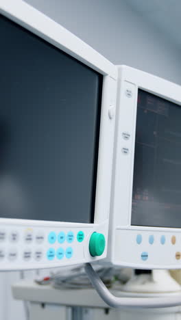 two monitors of the modern medical equipment in the ward. one screen is black and another is switched on. close up. vertical video