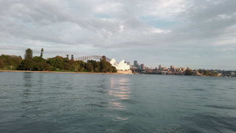 Blick-Auf-Das-Ikonische-Opernhaus-Von-Sydney-Mit-Der-Hafenbrücke-Von-Sydney-Dahinter-Von-Den-Gewässern-Von-Port-Jackson-In-Australien