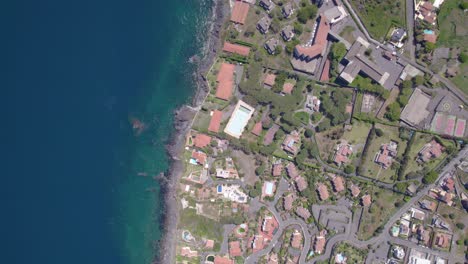 aerial top-down shot of the residential village on the mediterranean sea shore near catania, sicily, italy