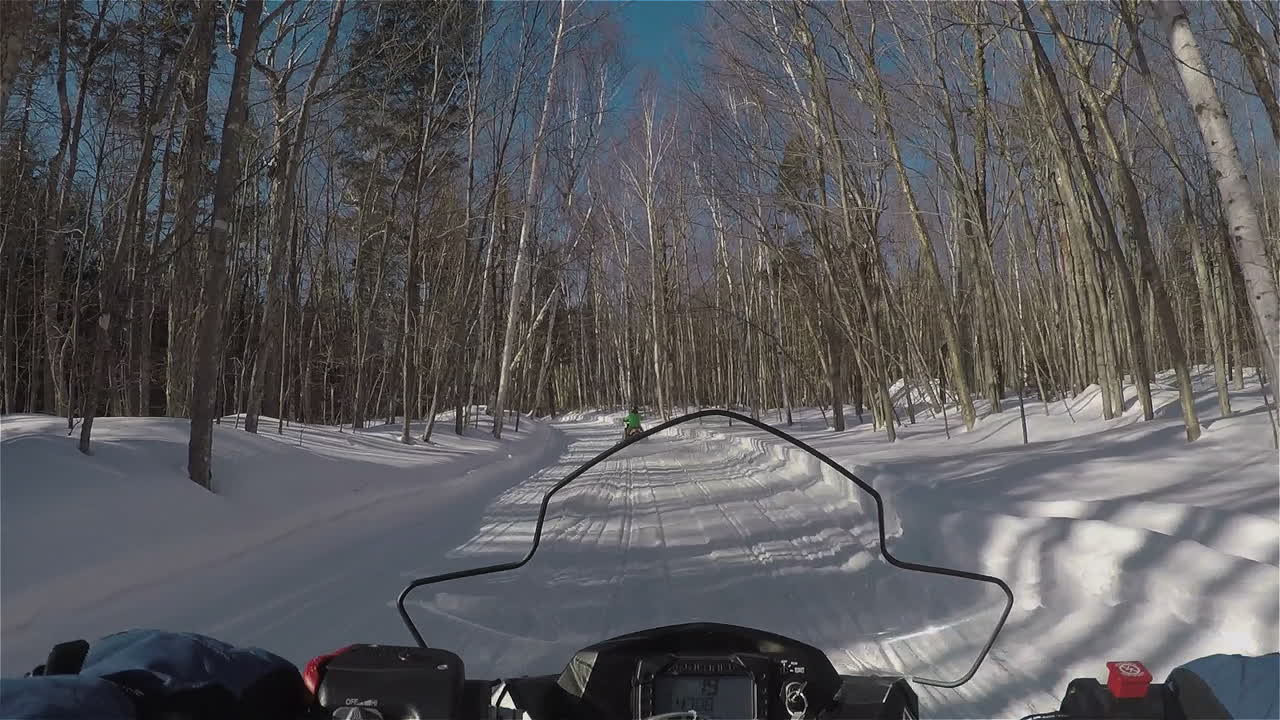Point of view shot of snowmobile speeding through a groomed wooded trail in New Hampshire