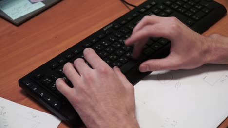 person typing on a keyboard at a desk