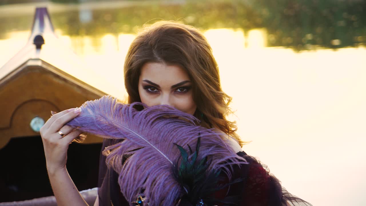 Beautiful brunette posing over beautiful romantic landscape. Traditional Venetian rowing boat