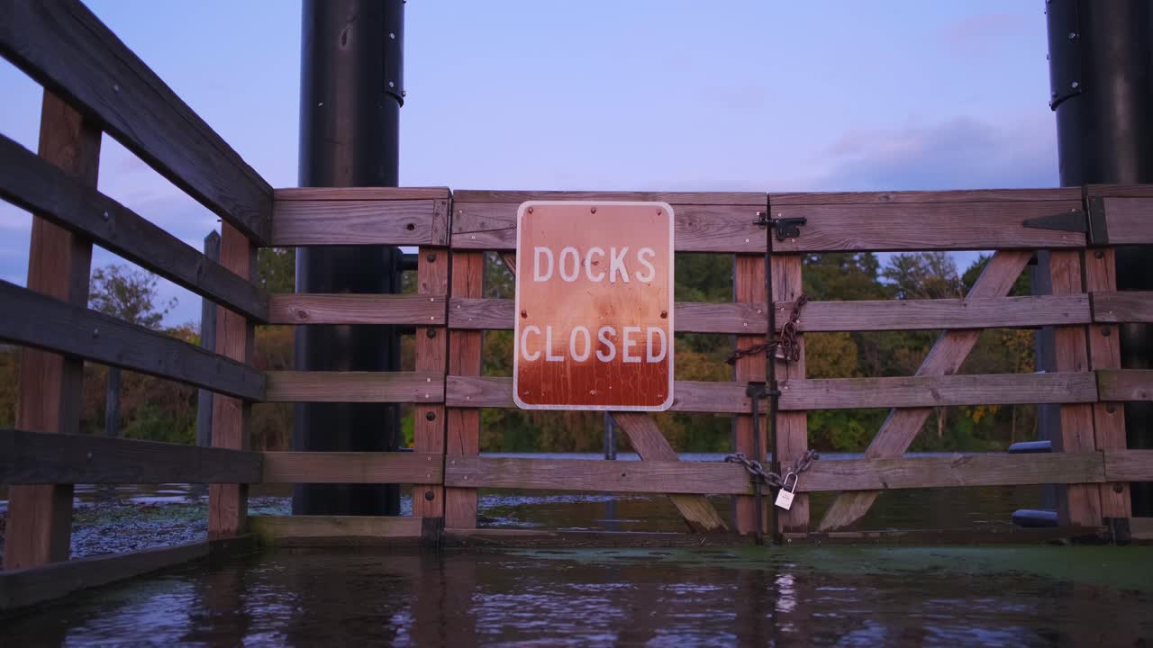 일몰 동안 폐쇄된 보트 부두 게이트에서 부두 폐쇄 표지판의 지상 샷