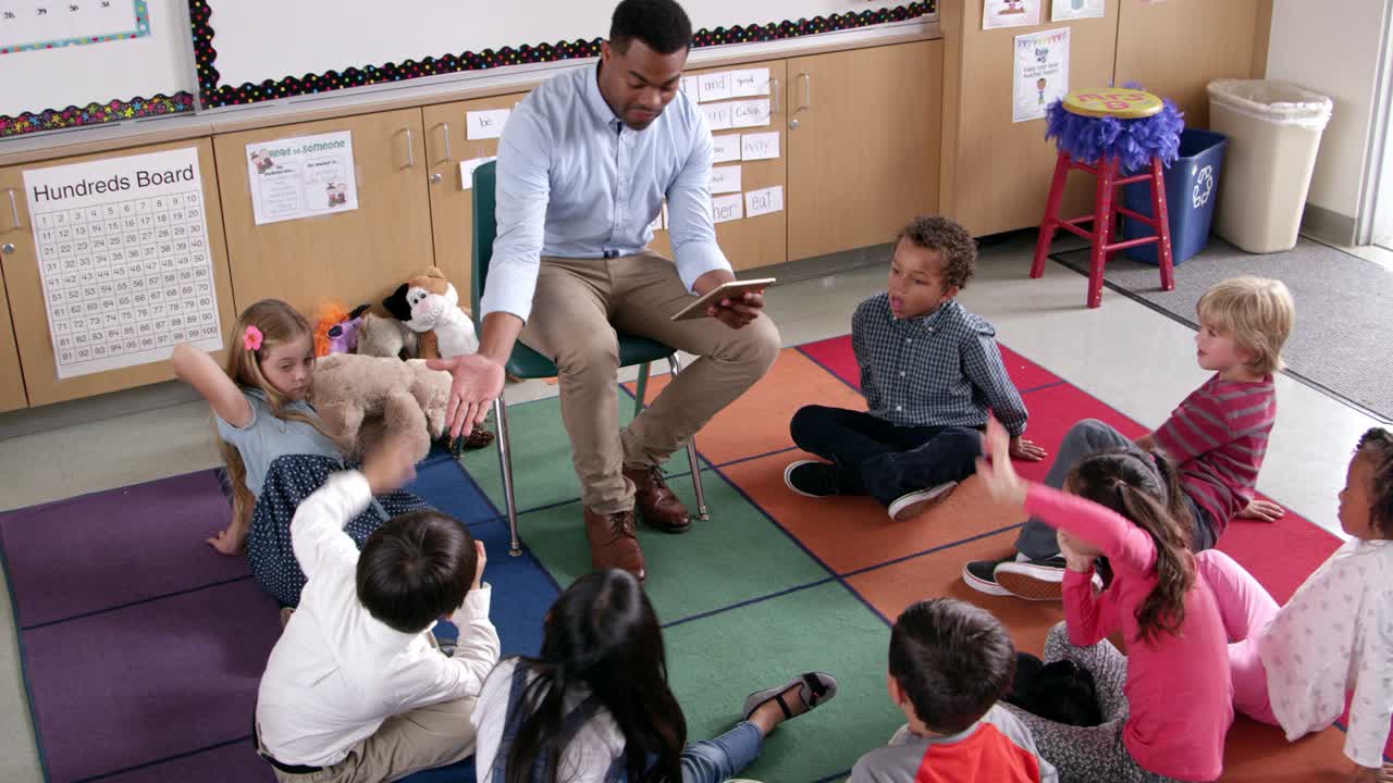 el maestro presenta el libro de cuentos a los alumnos jóvenes, vista elevada
