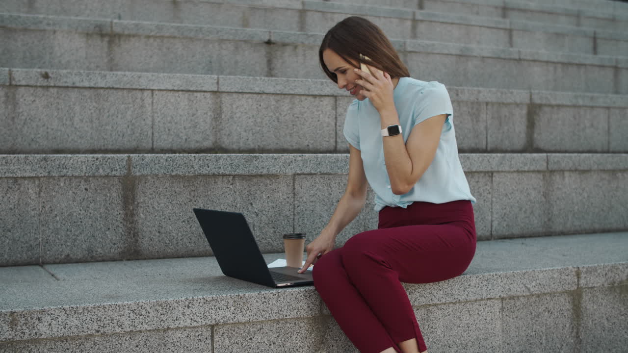 mujer de negocios hablando en un teléfono inteligente. profesional usando el touchpad en un portátil