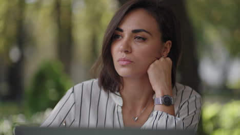 Talentosa-Mujer-Seria-Morena-Grupo-étnico-Hispano-Se-Sienta-En-Una-Mesa-En-Un-Café-De-Verano-Con-Una-Computadora-Portátil.-Considera-La-Solución-De-Problemas.-Mujer-De-Negocios-Desconcertada.-Retrato-De-Una-Hermosa-Mujer-De-Negocios