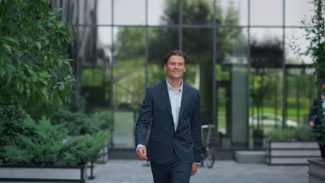 Confident-businessman-walking-downtown-complex-in-suit.-Successful-entrepreneur