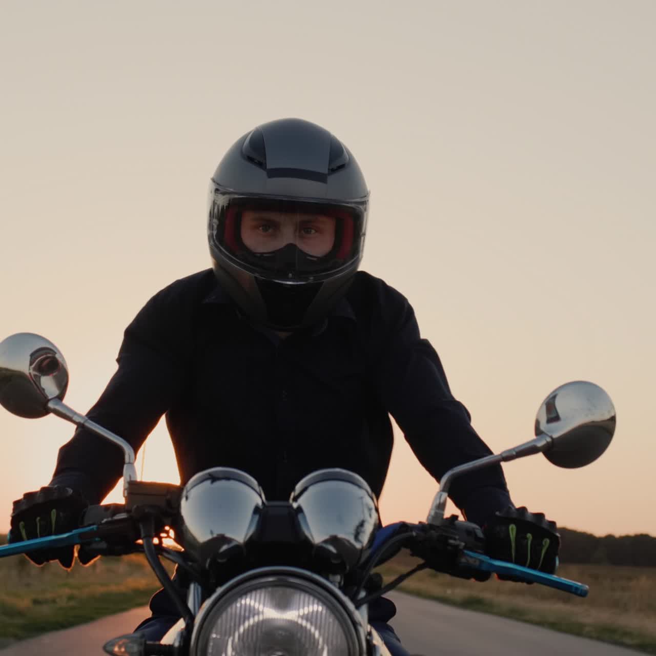 Un motociclista maneja una moto antes del atardecer 3