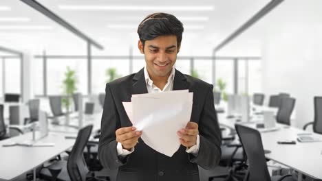 Happy-Indian-businessman-reading-the-contract