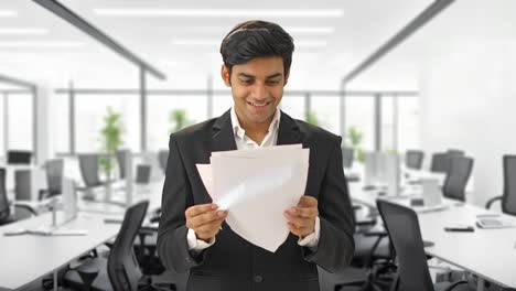 happy indian businessman reading the contract