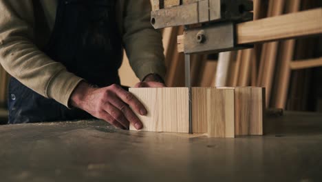 Close-up-view-of-a-carpenter-cutting-a-wood-into-pieces.-Works-with-electric-saw-machine.-Wood-dust-on-the-surface