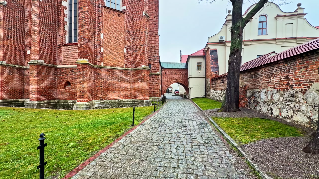 Peaceful walkway by red brick Corpus Christi Basilica exterior