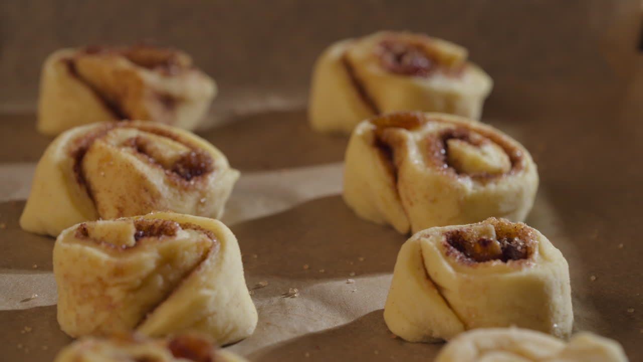 Cinnamon Rolls Ready For Baking Arrange In The Pan. - closeup slider shot