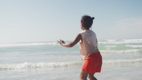 Rückansicht-Eines-Afroamerikanischen-Mädchens,-Das-Am-Strand-Springt-Und-Genießt