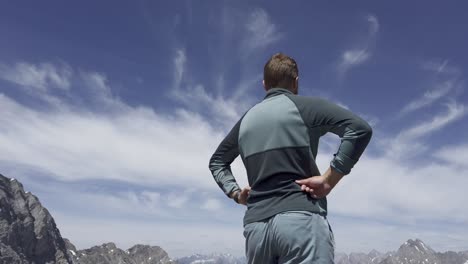 man mountain top watching view low angle sky, rockies, kananaskis, alberta canada