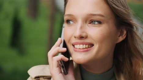 caucasian female student talking on the phone outdoors.