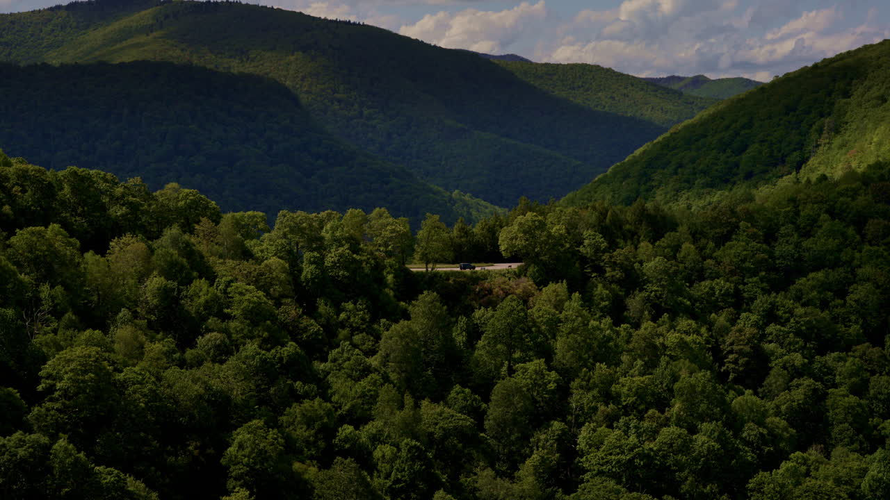 Slow, smooth, cinematic drone shot of blue ridge parkway with one truck on it